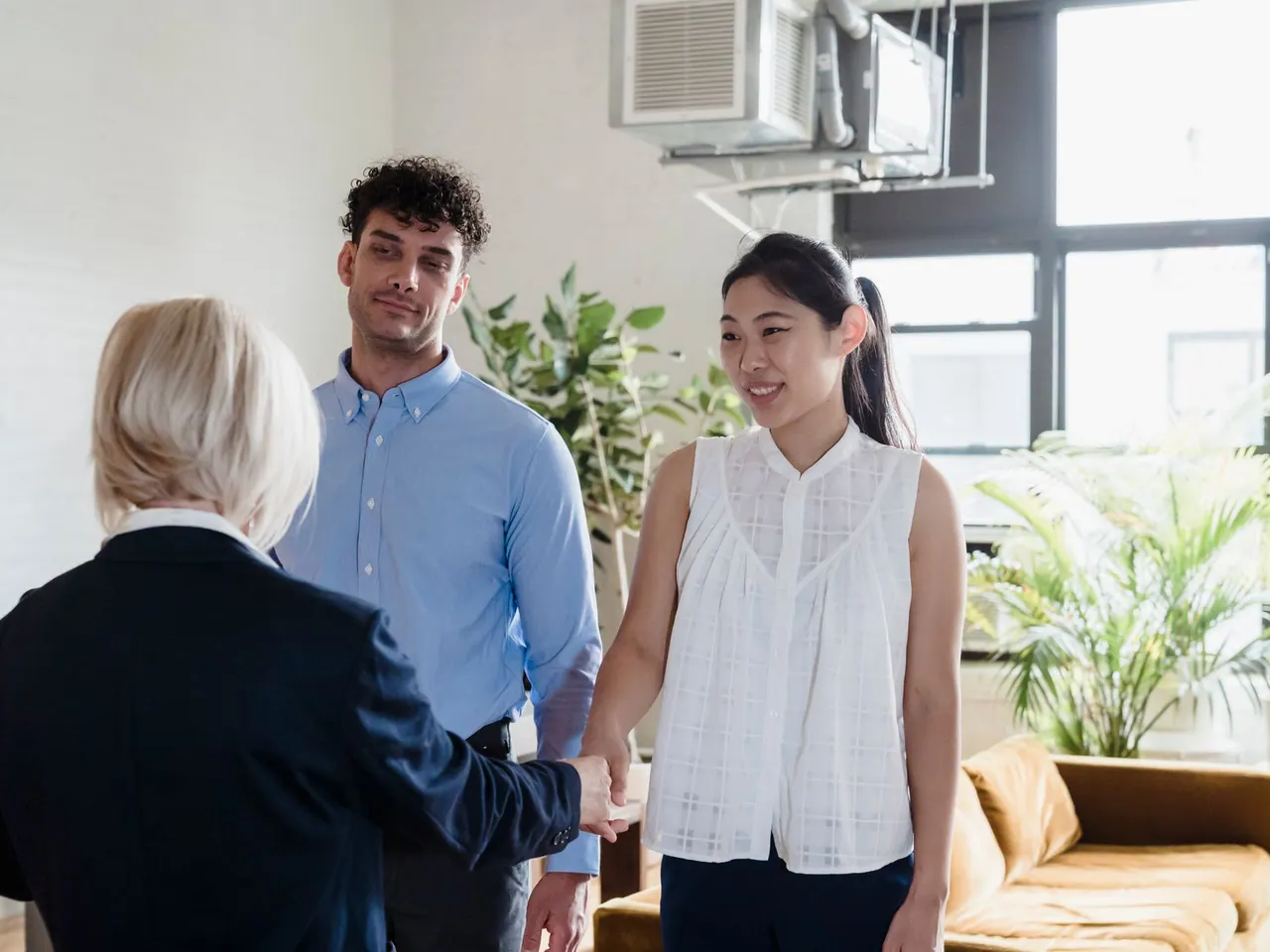 Handschlag zur Übergabe in einer hellen, fertig renovierten Wohnung