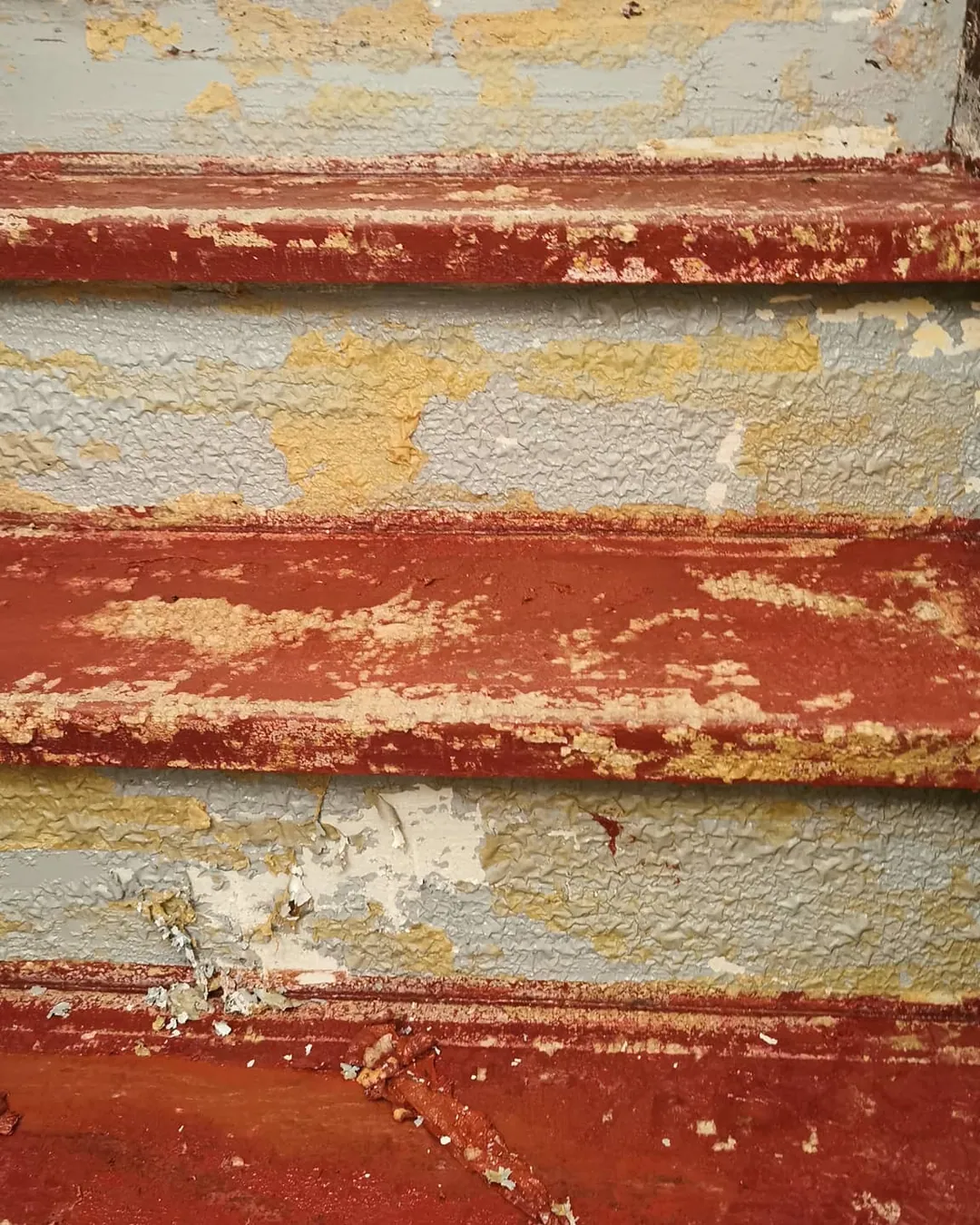Vorher: Alte Holztreppe mit abgeblätterter roter Farbe